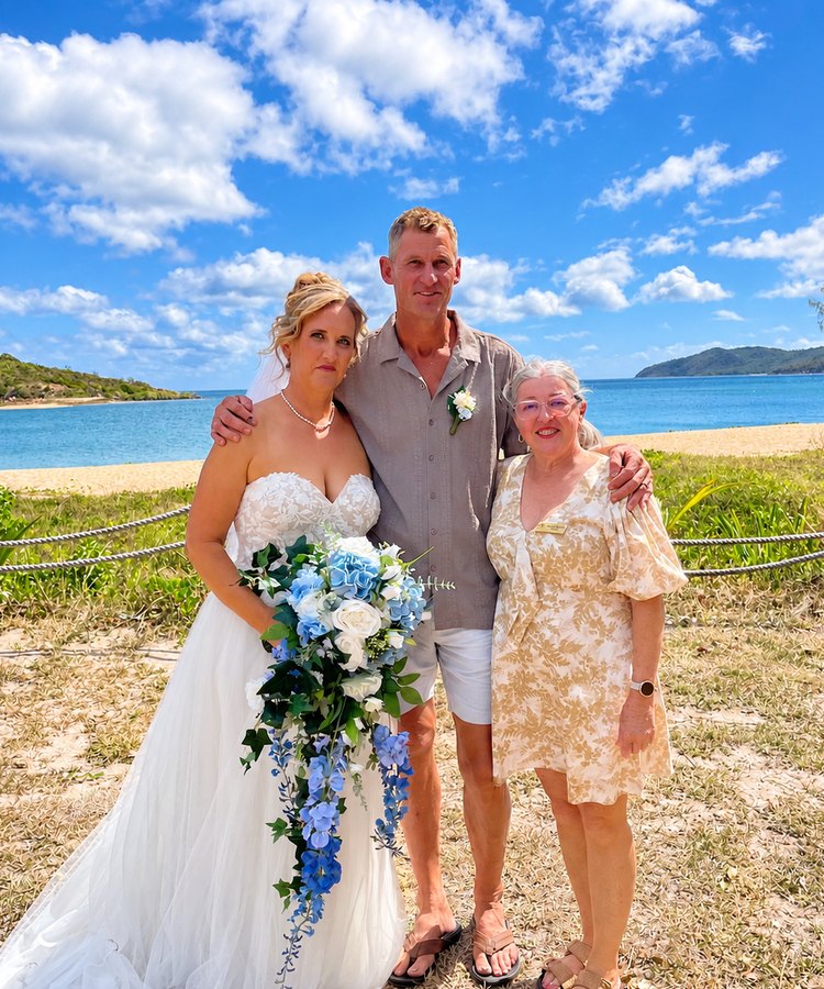 Leanne with a happy couple after their barefoot beach wedding in the Whitsundays